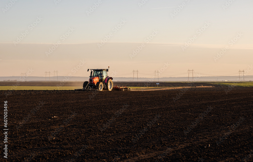 Fototapeta premium Farmer preparing his field in a tractor
