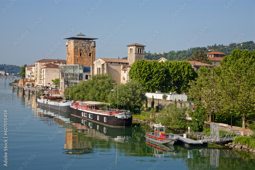 VIENNE, FRANCE, May 26, 2023 : Valois tower, built in 1336 by French King Philippe VI and Cordeliers church on the right bank of Rhone river.