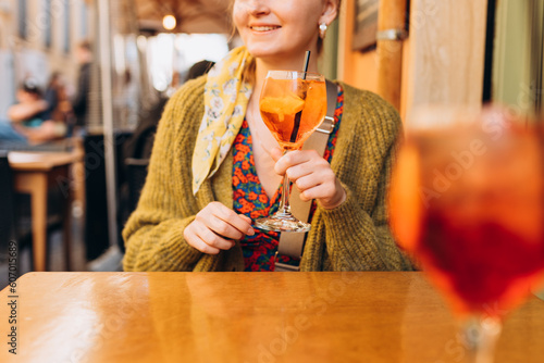 Canvas Print Happy 30s girl sitting on the cafe terrace on the city street