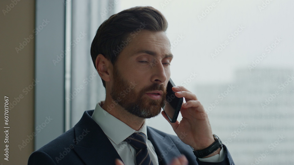 Financial consultant talking phone standing at office panoramic window close up Financial consultant talking phone standing at office panoramic window close up