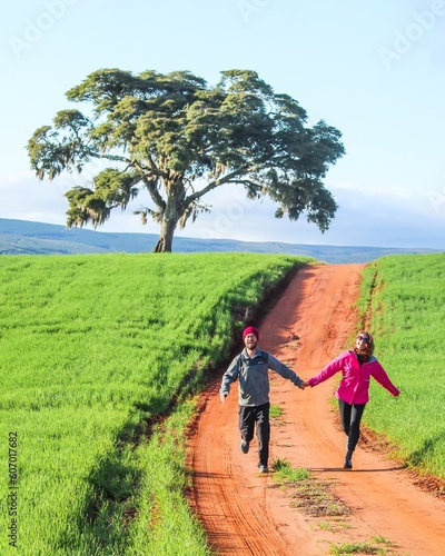 Casal de mãos dadas caminhando em plantações de soja, no Paraná 