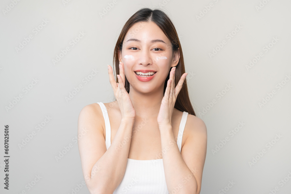Fresh healthy skin, beautiful smile asian young woman, girl happy applying moisturizer on her face, putting cream treatment before makeup cosmetic routine isolated on white background. Facial Beauty. Fresh healthy skin, beautiful smile asian young woman, girl happy applying moisturizer on her face, putting cream treatment before makeup cosmetic routine isolated on white background. Facial Beauty.