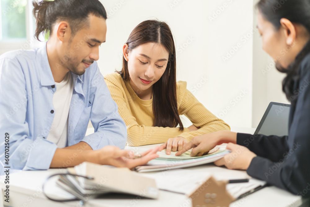 Happy asian couple client, people choose color on palette chart for swatch, paint on wall for new home with designer woman at office desk. Material of interior design. Happy asian couple client, people choose color on palette chart for swatch, paint on wall for new home with designer woman at office desk. Material of interior design.