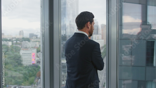 Worried man finish call standing near office window closeup. Manager thinking.