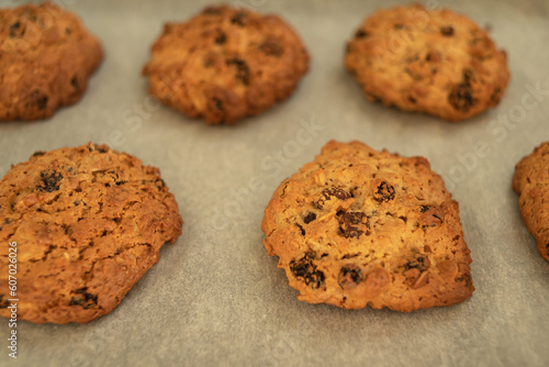 Freshly baked chewy oatmeal raisin cookies on a baking sheet.
