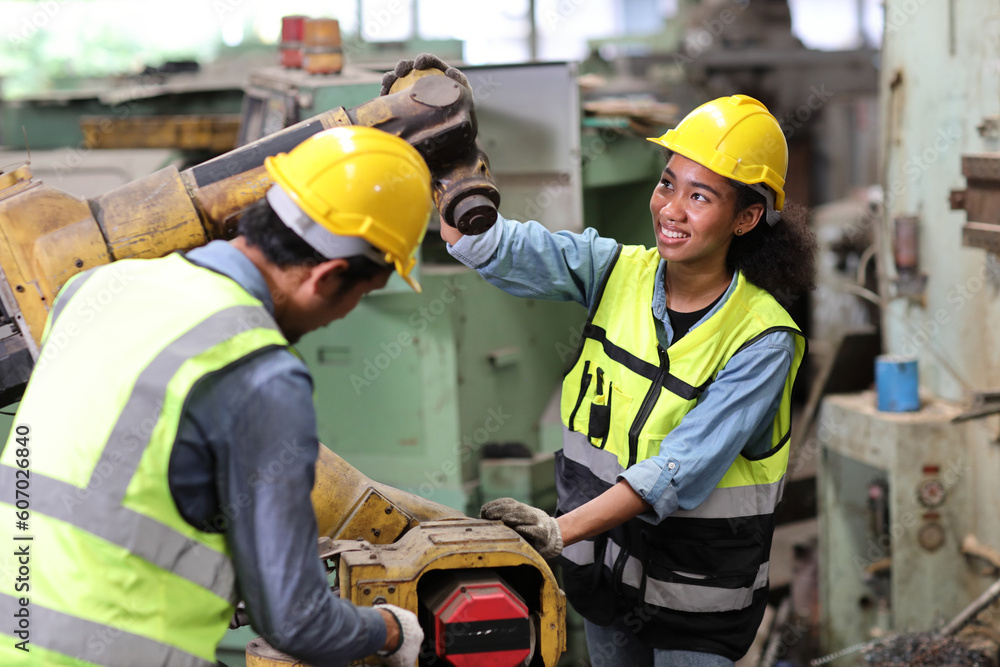 Group of professional heavy industry technician engineer in safety workwear repair part of broken robot arm machine in intelligent factory automotive. Industrial and technology support system concept Group of professional heavy industry technician engineer in safety workwear repair part of broken robot arm machine in intelligent factory automotive. Industrial and technology support system concept