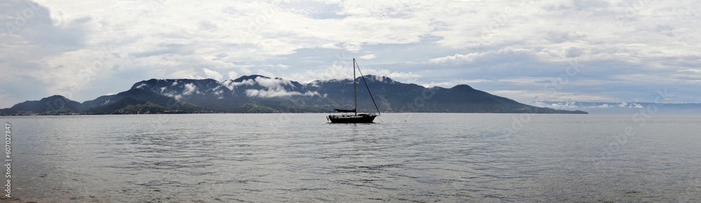 Small ship on the surface of a sea near the coast of Ilhabella island in Brazil