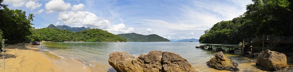 Scenic shot of waves crashing the shore of Ilha Grande island in Brazil with lush greenery on it
