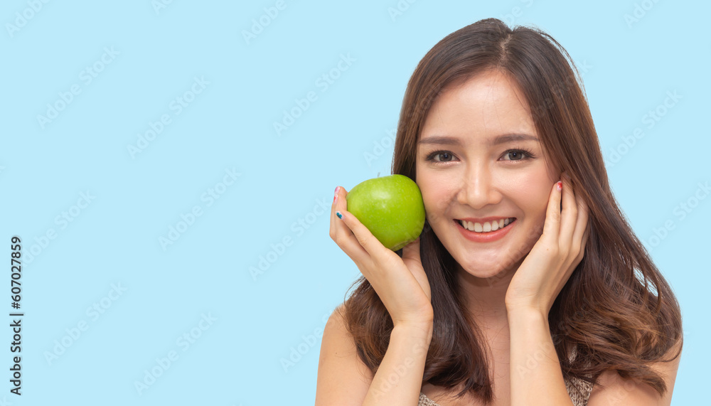 Portrait of beauty body slim healthy asian woman big smile with vegan food healthy holding apple, green apple, dental, teeth, fruit on blue.Diet.Fitness, healthy food Portrait of beauty body slim healthy asian woman big smile with vegan food healthy holding apple, green apple, dental, teeth, fruit on blue.Diet.Fitness, healthy food