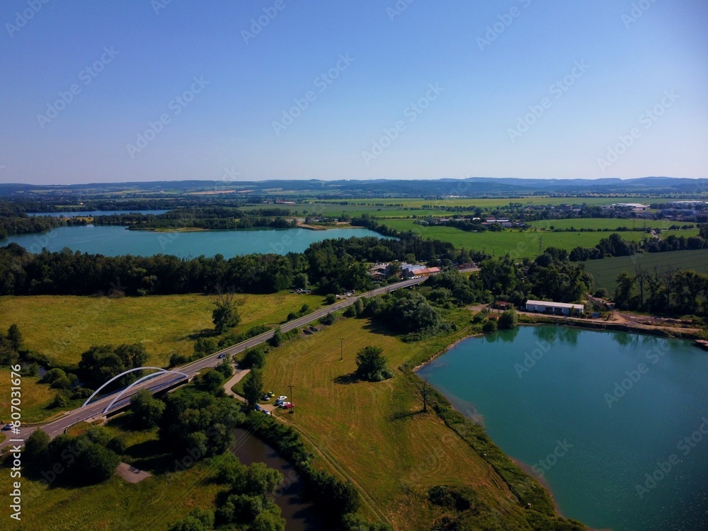 Aerial view of a river surrounded by trees with a blue sky in the background
