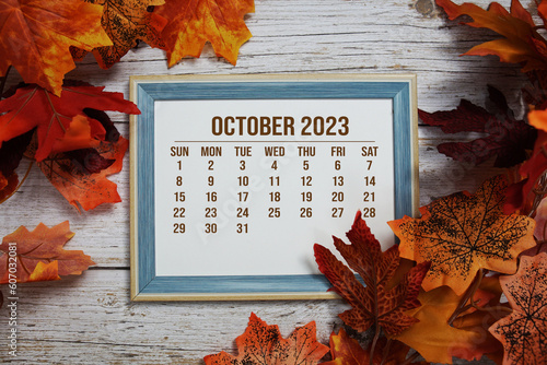 September 2023 monthly calendar maple leaf decoration on wooden background photo