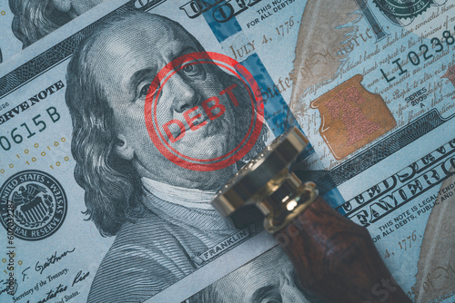 Benjamin Franklin face from USD dollar banknote with stamping debt wording for America's public debt is high and the debt ceiling needs to be raised concept. photo