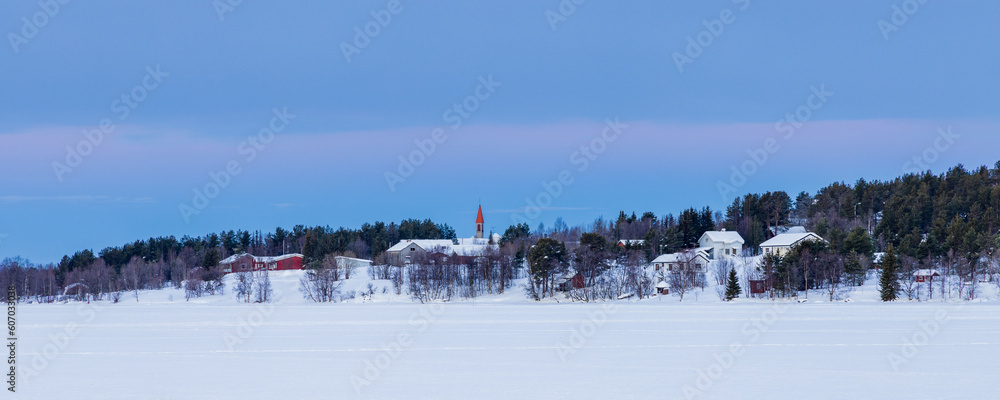 The village of Enontekiö during the blue hour as seen from the frozen Ounarsjärvi lake in Lapland, Finland