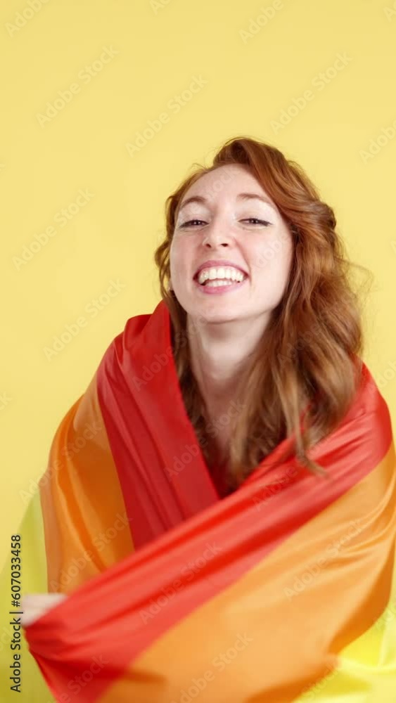 Happy redheaded woman wrapped with a lgbt flag Happy redheaded woman wrapped with a lgbt flag