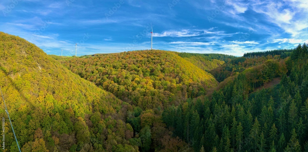 High-angle shot of beautiful green and yellow mountains with the bright blue sky in the background