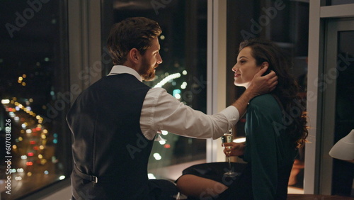 Confident man seducing woman sitting at window late evening. Happy couple date.