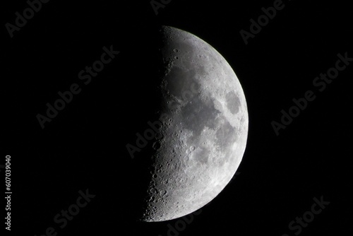 Closeup of a half-moon illuminating the dark night sky photo