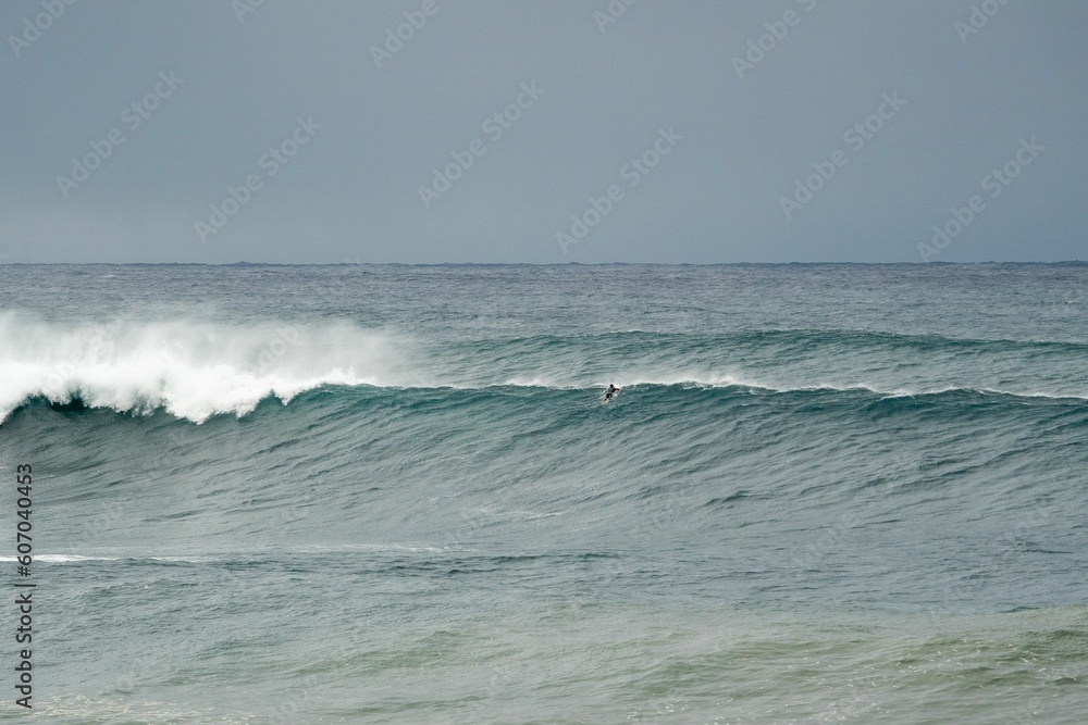 Scenic shot of a surfer catching a large wave at Wedding Cake Island, Sydney Scenic shot of a surfer catching a large wave at Wedding Cake Island, Sydney