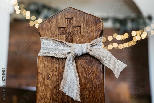 Φωτογραφία Closeup shot of a wooden pew in church with a bow on it and ferry lights blurred