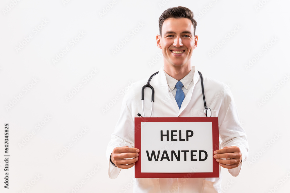 Image of doctor holding a paper with a text help wanted. Image of doctor holding a paper with a text help wanted.