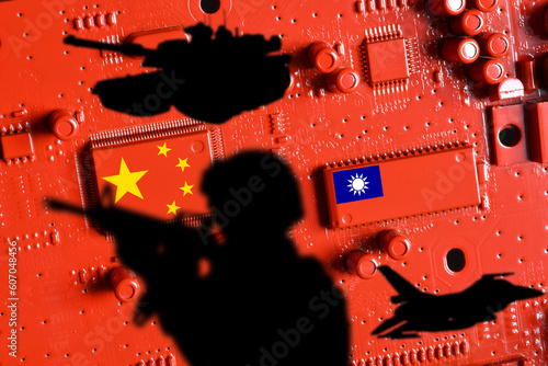 Flags of China and Taiwan on printed electronic board painted red with shadow of armed soldier, warplane and tank. World tensions for supremacy over the semiconductor industry and production. photo