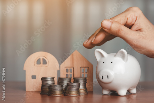 Hand covering a piggy bank ...