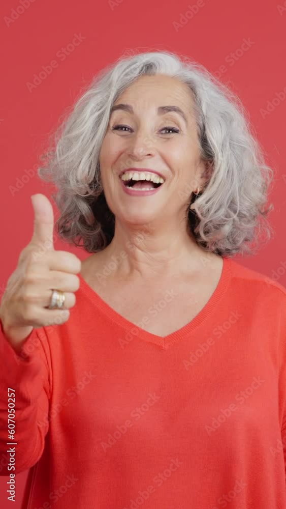 Mature woman gesturing agreement raising the thumb Mature woman gesturing agreement raising the thumb