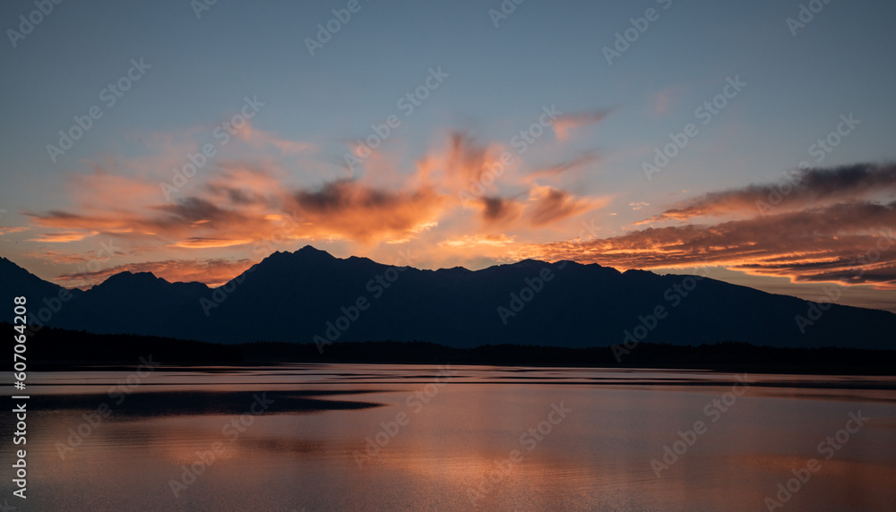 Grand Teton Range Stands In Silhouette Under Bright Orange Sky From Jackson Lake