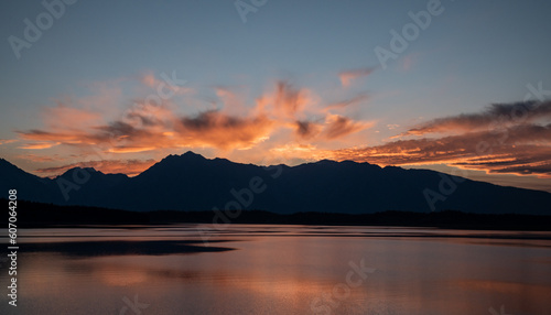 Grand Teton Range Stands In Silhouette Under Bright Orange Sky From Jackson Lake