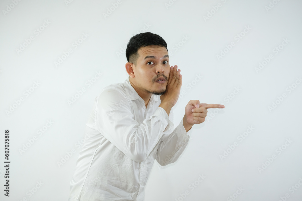 Young Adult Asian man whispering something and pointing to the right side Young Adult Asian man whispering something and pointing to the right side