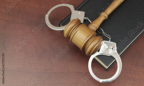 Judge gavel and handcuffs on legal book with copy space for text. Laws and court concept.