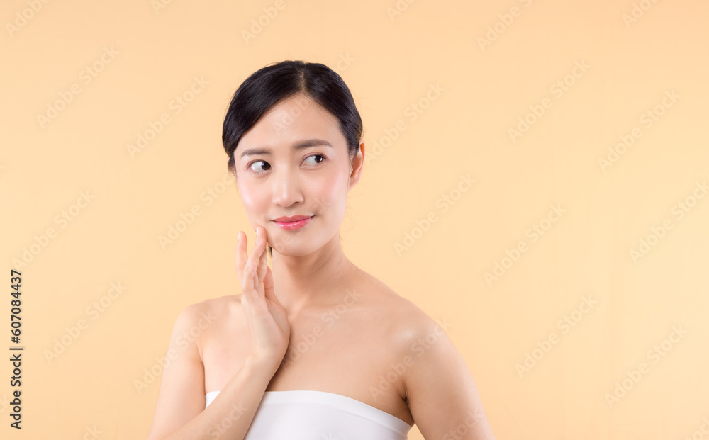 Beautiful girl asian model touching fresh glowing hydrated facial skin on beige background closeup. Beauty face young woman with natural makeup and healthy skin portrait. Skin care concept Beautiful girl asian model touching fresh glowing hydrated facial skin on beige background closeup. Beauty face young woman with natural makeup and healthy skin portrait. Skin care concept