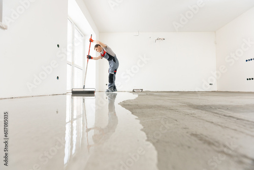 Leveling with mixture of cement for floors. Worker use screed concrete epoxy for level photo