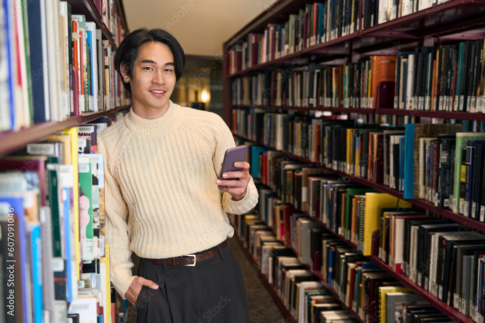Stylish Japanese university student holding mobile phone and looking camera Stylish Japanese university student holding mobile phone and looking camera