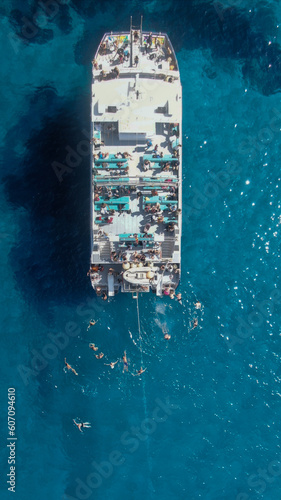 Top aerial view of a boat tour in the water of the island of the Mediterranean sea. Holiday, trip, excursions concept