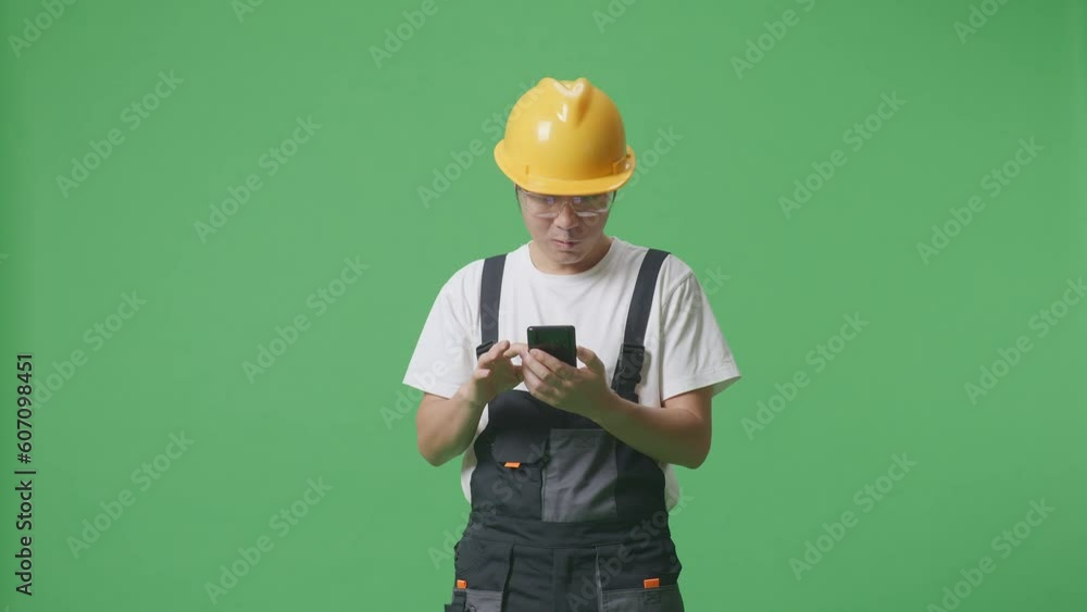 Asian Man Worker Wearing Goggles And Safety Helmet Looking At Smartphone, Smiling, And Saying Wow While Standing In The Green Screen Background Studio
Asian Man Worker Wearing Goggles And Safety Helmet Looking At Smartphone, Smiling, And Saying Wow While Standing In The Green Screen Background Studio