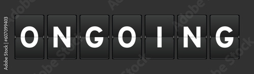 Black color analog flip board with word ongoing on gray background