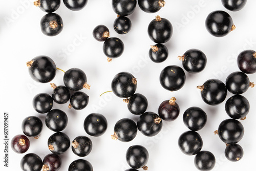 Ripe blackcurrant berries are scattered, top view. Isolated on a white background.