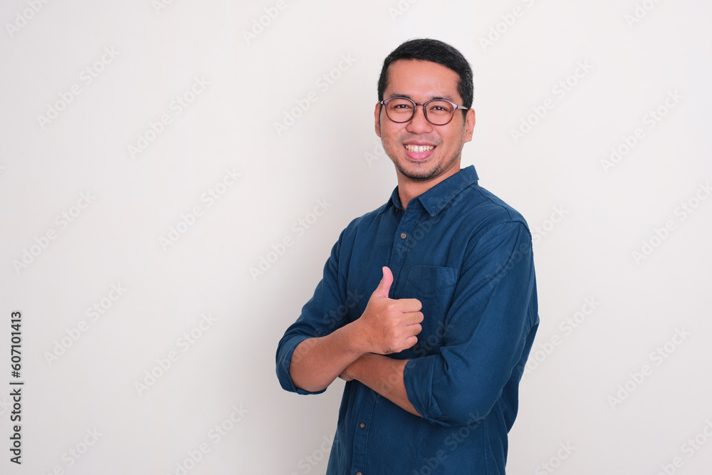Side view of adult Asian man smiling confident and give thumb up