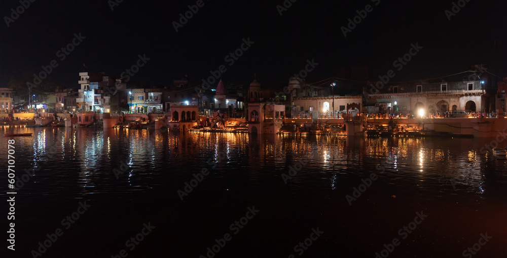 general night view, sacred place on govardhan hill in india, place of pilgrimage, shrine of believers, manasi ganga lake, people light fire lamps