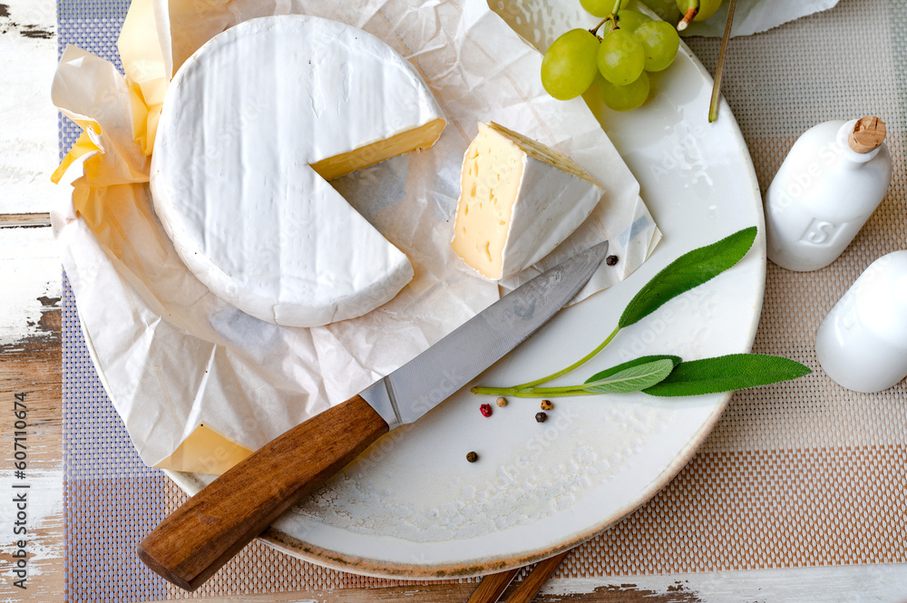 Fotografie Ausgepackter Camembert Käse auf einem Teller