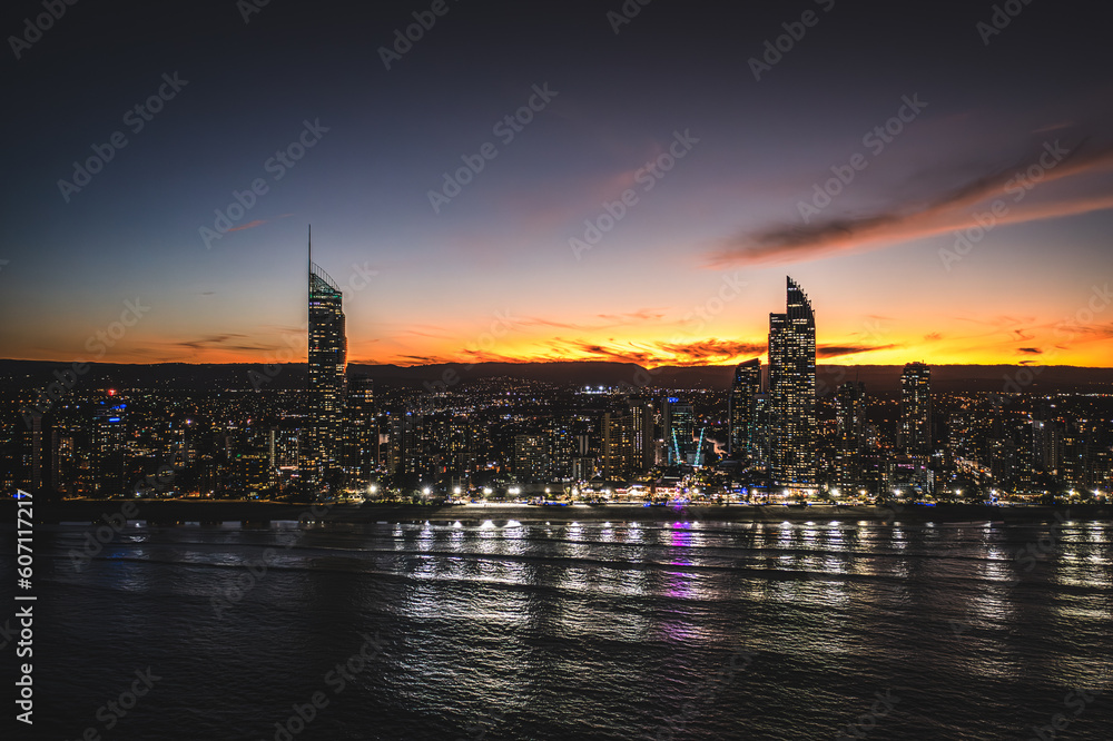 Fototapeta premium Golden Horizon: A Mesmerizing Aerial Sunset View of Surfers Paradise's Downtown Skyscrapers Embracing the Ocean
