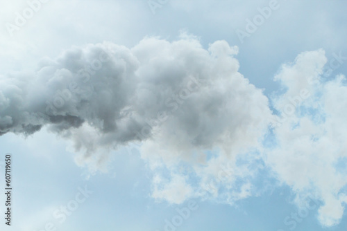 Thick smoke from chimney of chemical plant over cloudy sky background