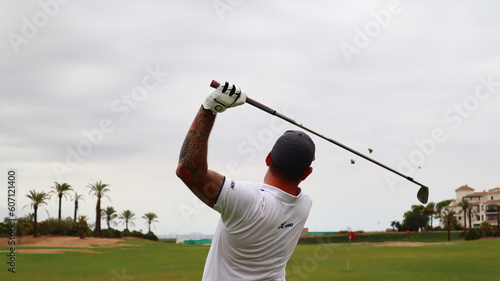 Professional golfer with one arm hitting the ball on the golf course. Concept of willpower of people with disabilities in sport. 