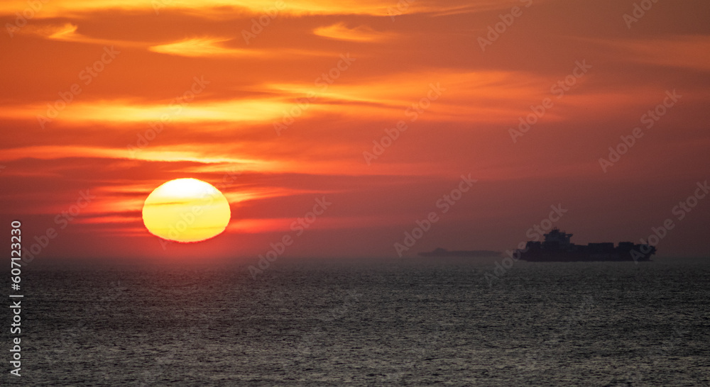 sunset in virginia beach with cargo ship n distance
