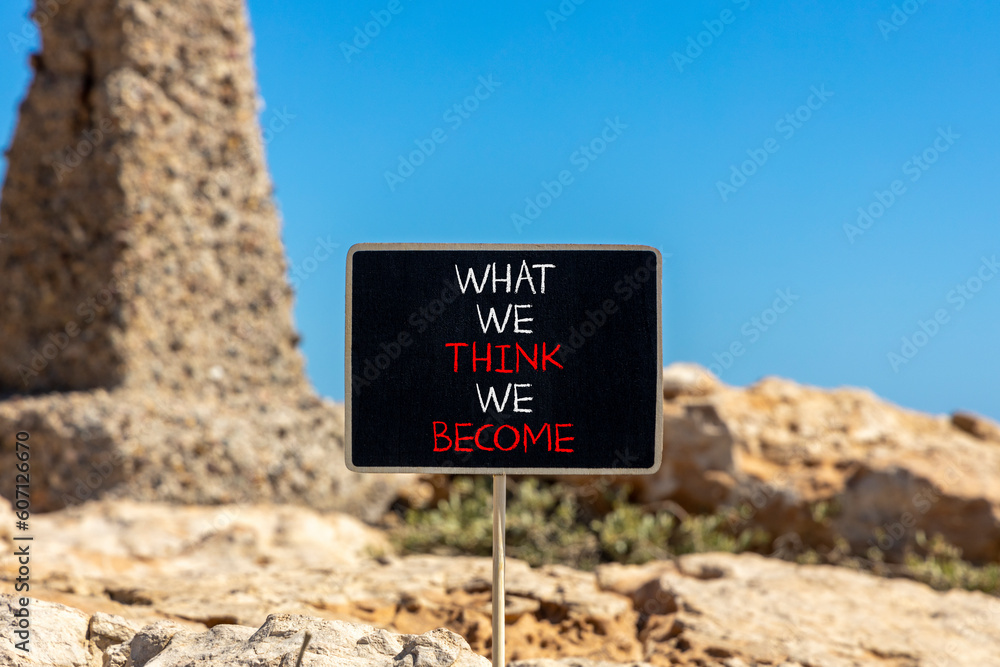 We become or think symbol. Concept word What we think We become on beautiful black chalkboard. Beautiful stone blue sky background. Business we become or think concept. Copy space.
