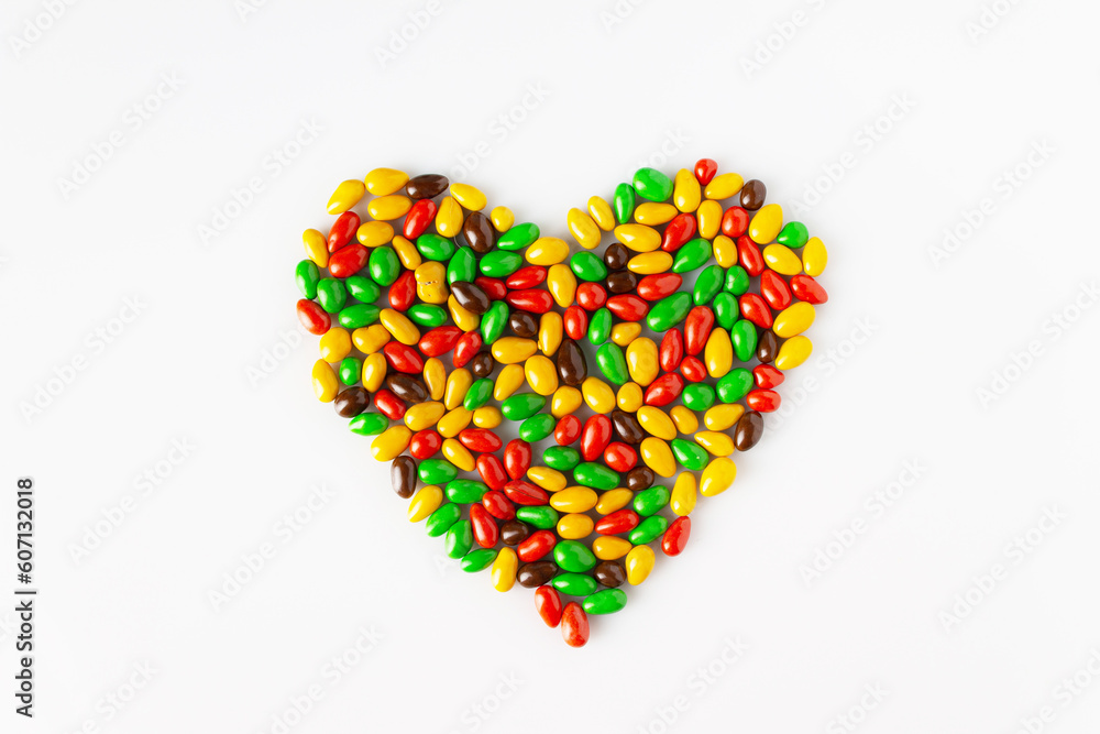 sunflower seeds in colored glaze in the shape of a heart on a white background