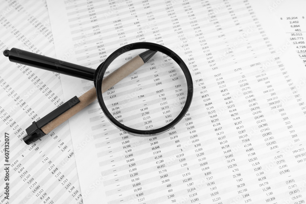 Magnifying glass and pen on financial statement. Magnifying glass and pen on financial statement.