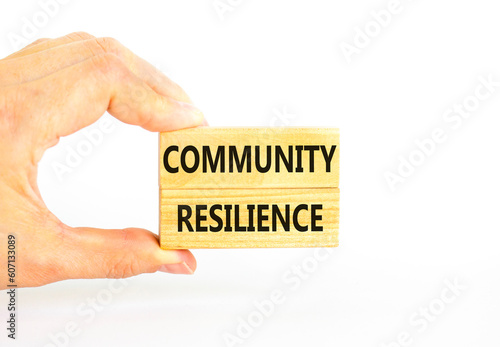 Community resilience symbol. Concept word Community resilience typed on wooden blocks. Beautiful white table white background. Businessman hand. Business and community resilience concept. Copy space.