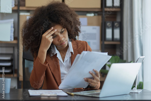 Young African American businesswoman are stressed and tired from work sitting at desk in the office, feeling sick at work, stress from work. 